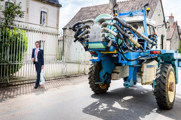 Bridegroom walking through a Burgundy wine village before the wedding
